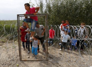 Σύρος πρόσφυγας πηδάει τον φράχτη, στα ουγγροσερβικά σύνορα, κοντά στο Ασοθάλομ. Φωτογραφία: Laszlo Balogh/Reuters