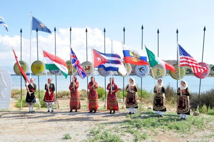 Από τον εορτασμό, 29.9.2015. Κοπέλες με παραδοσιακές ενδυμασίες υψώνουν σημαίες των συμμάχων χωρών (ΗΠΑ, Καναδάς, Ιρλανδία, Κούβα, Ουγγαρία, Ρωσία). Πηγή: ιστοσελίδα του Υπουργείου Εθνικής Άμυνας (www.mod.mil.gr)