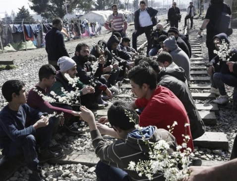  Διαμαρτυρία προσφύγων, που κάθονται στις γραμμές του τρένου, κρατώντας λουλούδια στα χέρια.Ειδομένη,,1.3.2016.Φωτογραφία EFE